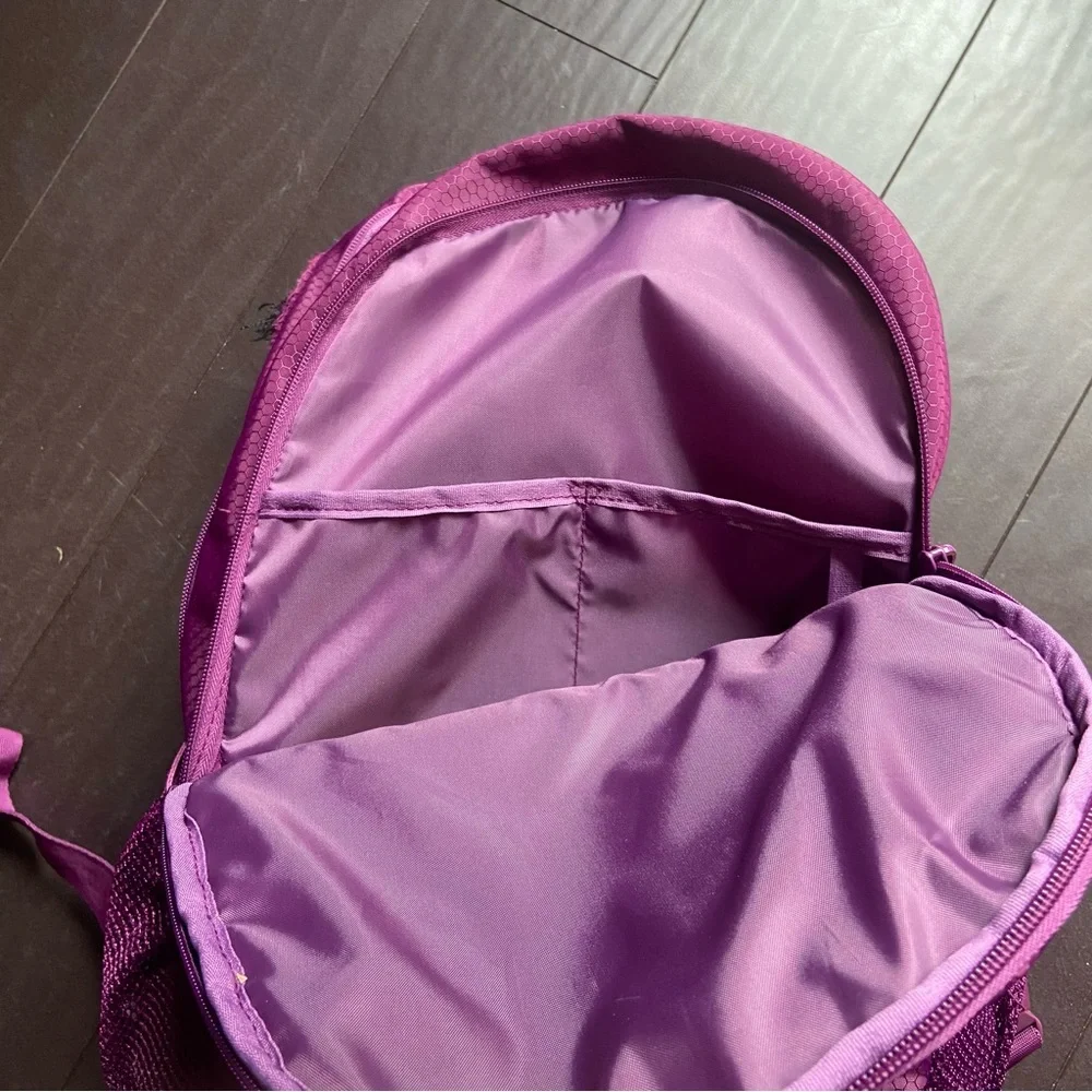 Purple Reebok book bag with tear right near strap